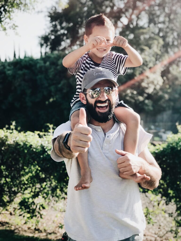 Child happily riding on their parent's shoulders